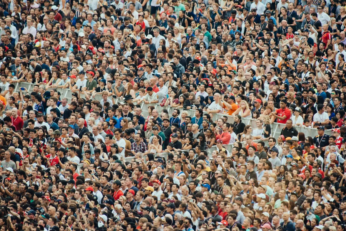 A dense crowd of thousands of event attendees, photographed from above.