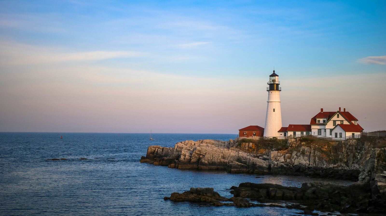 White lighthouse near body of water.